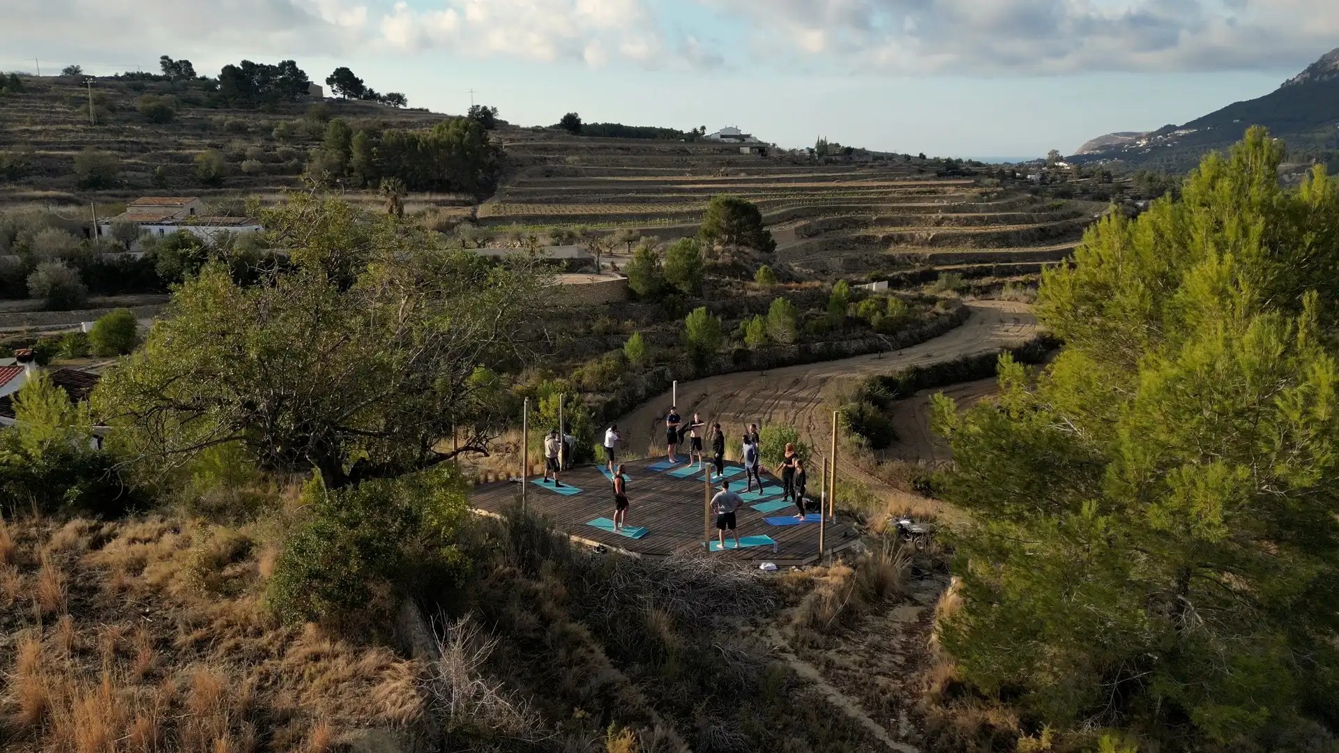 A training deck in the hills above Calpe, the group on their mats in the morning sun
